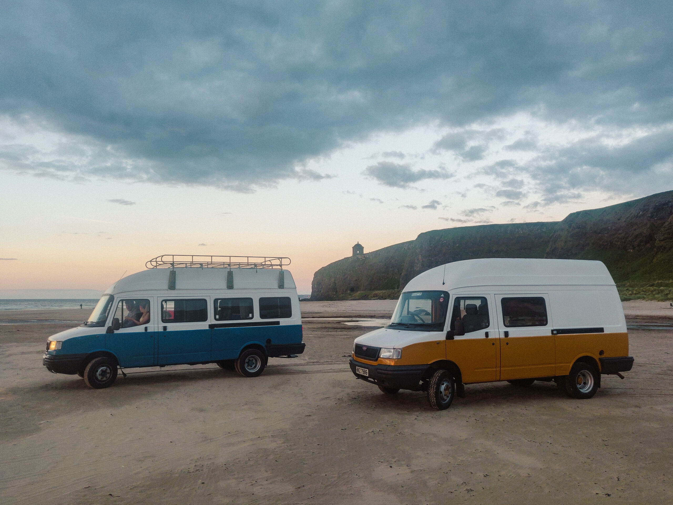 Two campervans parked on beach