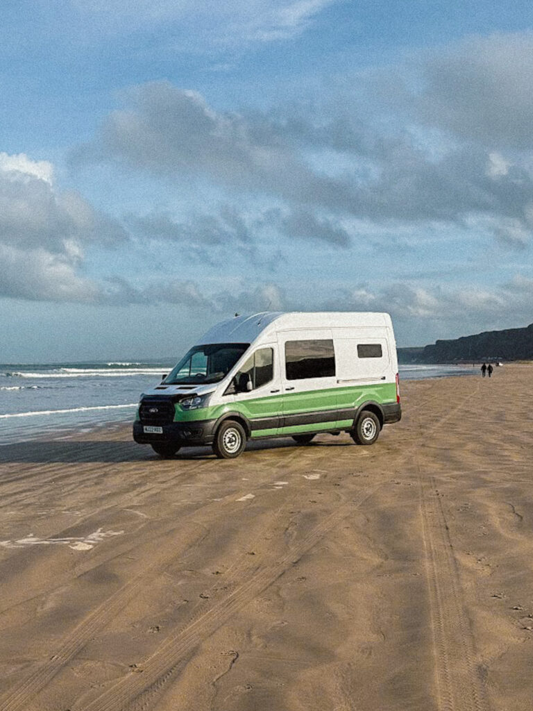 Campervan parked on sandy beach